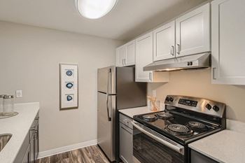 a kitchen with white cabinets and stainless steel appliances
